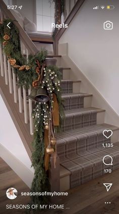 the stairs are decorated for christmas with greenery and bells on each handrails