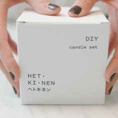 two hands holding a white box with black and silver designs on it that says diy