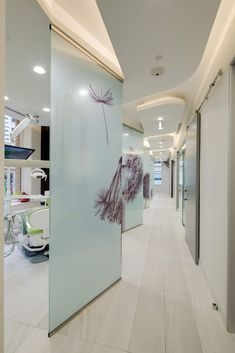 an office hallway with glass partitions and artwork on the wall