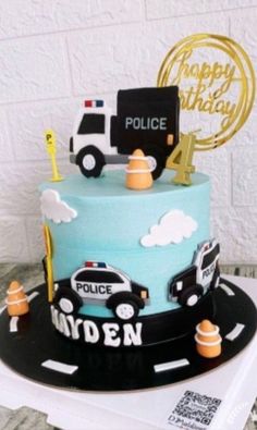 a police cake is decorated with blue frosting and black icing, along with the words happy birthday written on it