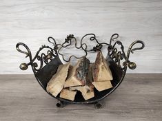 a firewood rack with several logs in it on top of a wooden floor next to a white wall