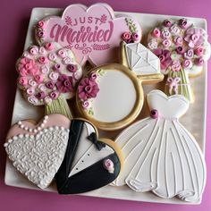 decorated cookies on a white plate with pink flowers and bride's dress, groom's cake