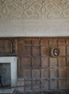 an old room with wood paneling and a fire place in the corner on the wall