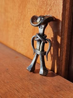 a metal figurine sitting on top of a wooden shelf next to a door