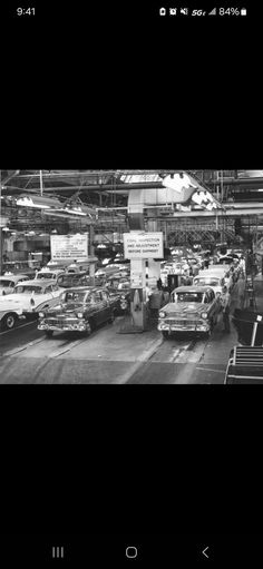 an old black and white photo of cars on the assembly line at a car factory