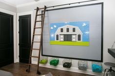 a room with a ladder and pictures on the wall