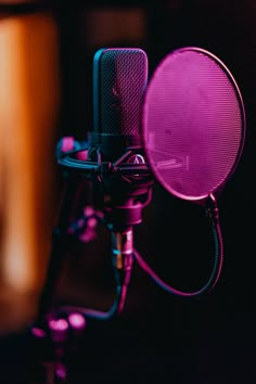 a microphone with a purple light on top of it in front of a black background