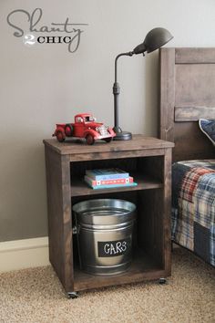 a toy truck sitting on top of a wooden shelf next to a lamp and bed