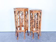 pair of bamboo side tables with rattan tops on concrete floor in front of white wall