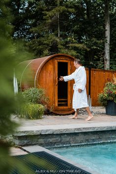 a man in a bathrobe walking towards a pool