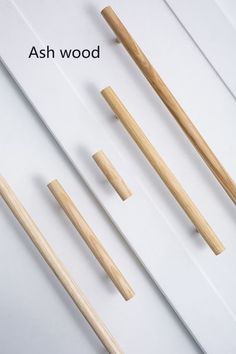 four wooden chopsticks are shown with the words ash wood written below them in black