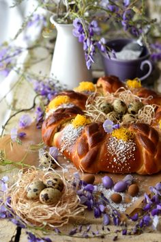 some kind of bread that is sitting on a table with purple flowers and other things