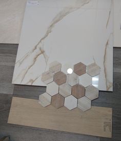 some white and brown marble tiles on top of a wooden table with a light in the middle