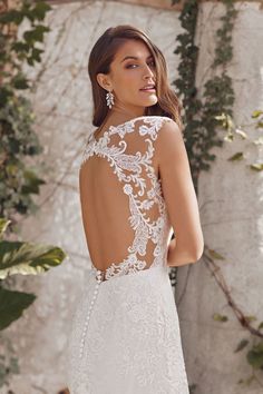 the back of a wedding dress with an open neckline and lace detailing on it