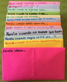 a stack of colorful envelopes sitting on top of a green table covered in writing