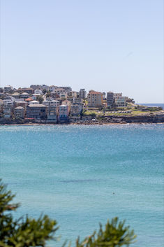 the water is very blue and clear with houses in the backgrouds behind it