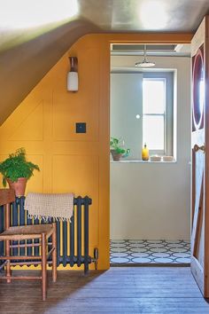 an open door leading to a room with yellow walls and wood flooring on the other side