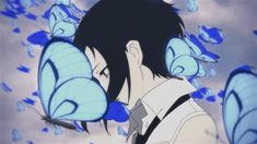 a man with black hair and blue butterflies on his head looking at something in the sky