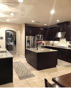 a large kitchen with dark wood cabinets and granite counter tops