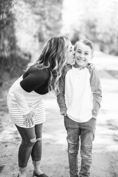 a mother kissing her son on the cheek while he kisses his daughter's forehead