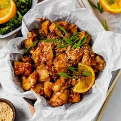 chicken with oranges and sesame seeds in a bowl