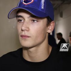 a young man wearing a blue hat and black shirt