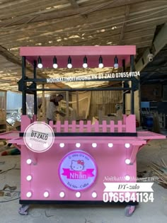 a pink and black food cart with lights on it's sides in a warehouse