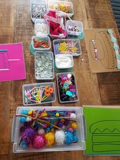 several plastic containers filled with craft supplies on top of a wooden table