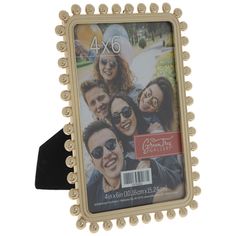 a gold frame with beaded edges and an image of four people in the background