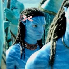 two men with blue skin and braids standing next to each other