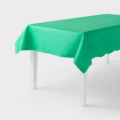 a table with a green cloth on it and two white legs in front of the table