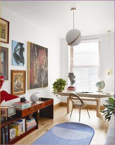 a living room filled with furniture and pictures on the wall next to a table in front of a window