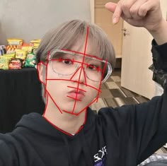 a young man wearing glasses with red lines drawn on his face to help him understand what he is doing