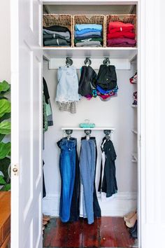 an open closet with clothes hanging on the wall