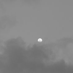 an airplane flying in the sky with a full moon behind it's back end