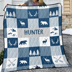 a woman holding up a quilt that says hunter