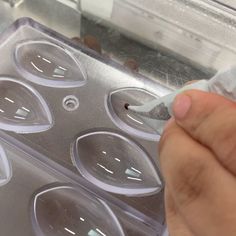 a person holding a plastic container with some food in it's hand and looking at the lid