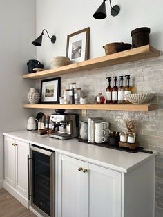 a kitchen with open shelving and lots of bottles on the shelfs above it