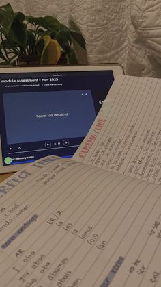 a laptop computer sitting on top of a wooden desk next to a pile of papers