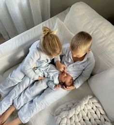 two children are sitting on a white couch