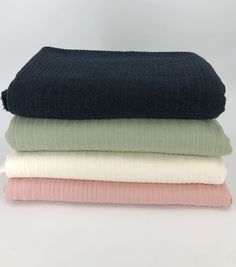 four folded blankets stacked on top of each other