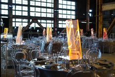 tables and chairs are set up for an event with clear glassware on the table