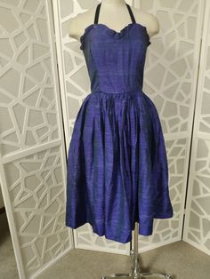 This is the sweetest Thai silk cocktail dress with sweetheart neckline with a tiny ruffle, fitted boned bodice, is waisted with a very gathered skirt to below knee length. There is a back nylon zipper and the dress is lined. The fabric is just beautiful with its royal blue with a green glow through it. The dress was designed to be strapless but it has had an elastic halter neck tie added. The condition is good except for a tiny break in the ruffle but barely noticable. Best fit around a 10au Bus Dress Small Bust, Dress With Sweetheart Neckline, Thai Silk, Boned Bodice, Silk Cocktail Dress, Gathered Skirt, Small Bust, Dress Clothes For Women, Halter Neck