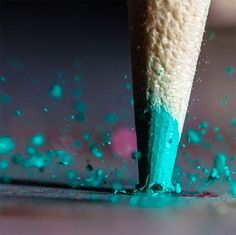 a pencil with blue and green ink on it's tip sticking out of the ground