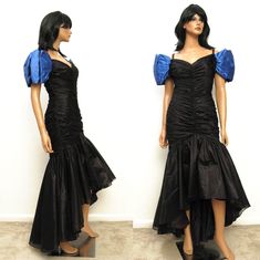 "This is a gorgeous vintage prom dress from the 1980s.  The main body of the dress is made out of a sheer black chiffon, and it is fully lined in black acetate.  The upper part of the dress has a fitted wiggle cut with a ruched design and mild boning for support.  The skirt of the dress is made out of a full circle of material, and there is an attached layer of netting underneath to help show off the fullness, creating the mermaid look.  The dress has short cap sleeves made out of blue satin.  The sleeves fall off the shoulder, and there are little straps that go over the shoulder area.  The dress is longer in the back than in the front, creating a dramatic asymmetric hem.  It closes with a zipper down the back. The tag labels this a size 9/10.  However, the dress looks like it was profess 80s Mermaid, Mom Prom, 80s Dress Vintage, 1980 Dress, Retro Prom, Hi Low Gown, Sketchbook Practice, 1980s Prom, Mermaid Look