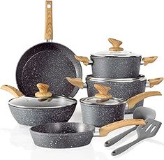 an assortment of pots and pans with wooden spoons in them on a white background