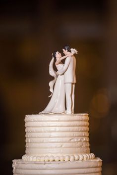 a wedding cake with a bride and groom figurine on top