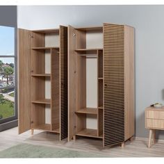 two open wooden closets sitting on top of a hard wood floor next to a window