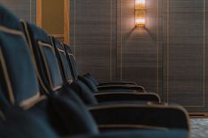 rows of blue chairs in front of a wall with a lamp on it's side