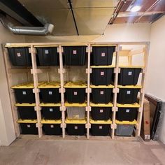 the storage room is filled with black boxes and yellow bins on wooden pallets